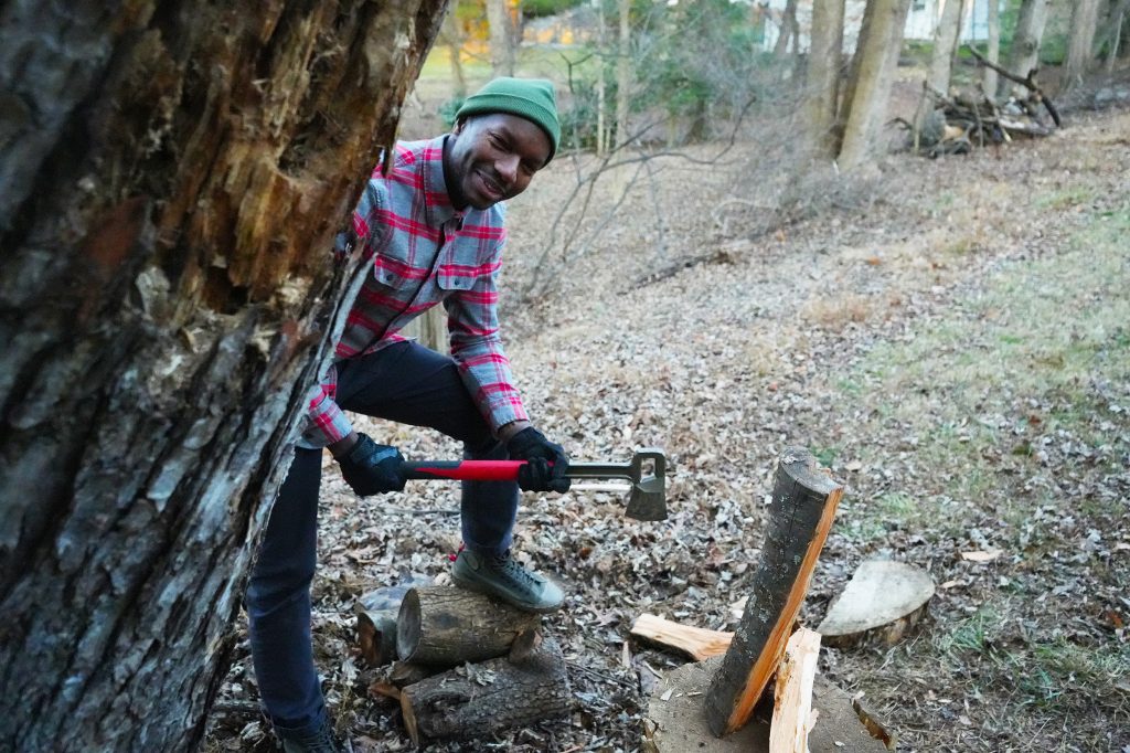 Man with axe peeking around a tree