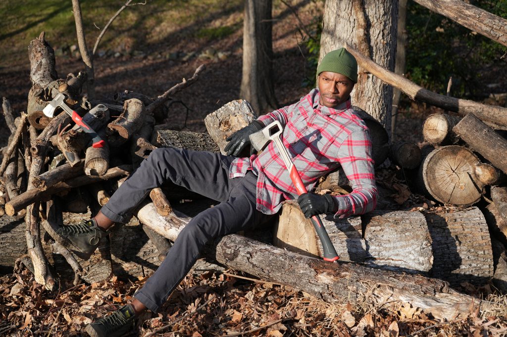 Man resting on wood with an axe, front view
